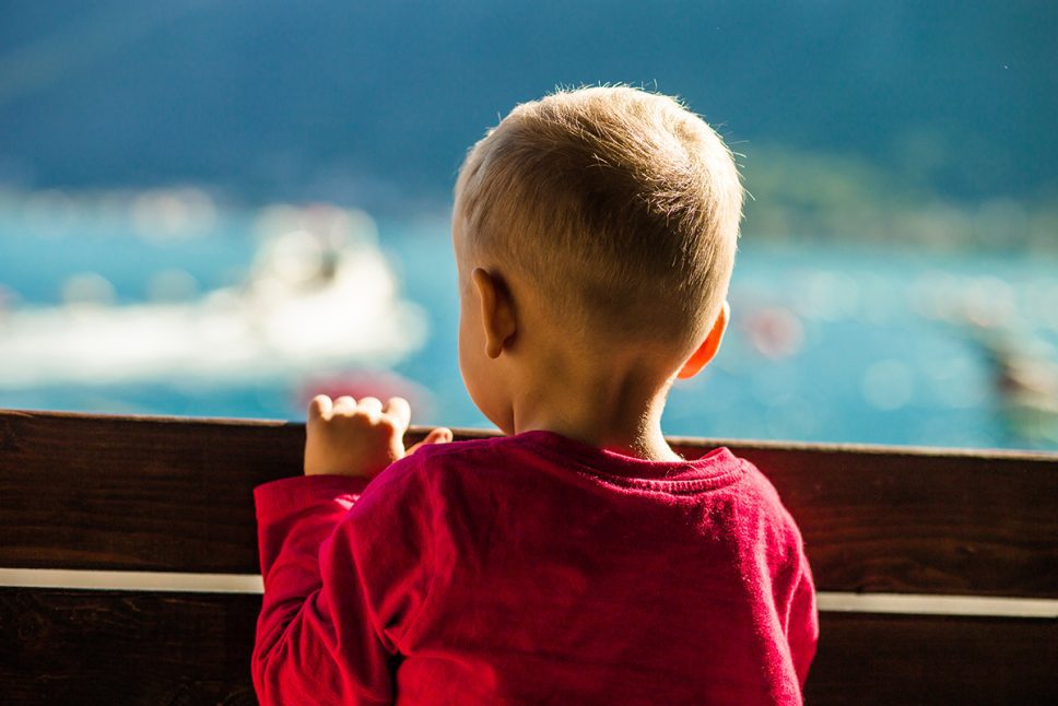 a-little-boy-looks-into-the-distance-at-the-ships-in-the-sea